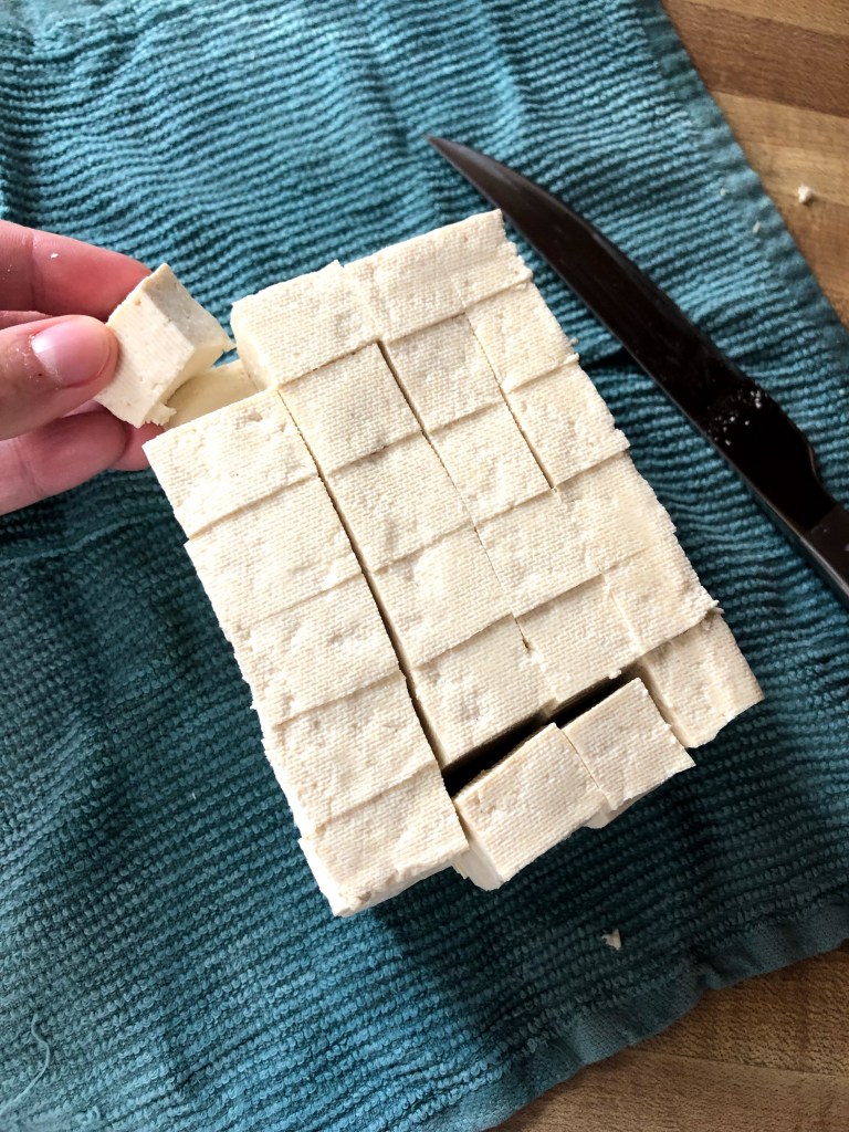 Firm tofu has been pressed and now diced into bite-size pieces.