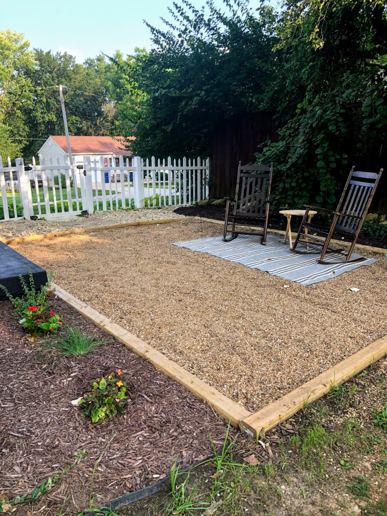 A finished pea gravel patio in a cottage backyard.