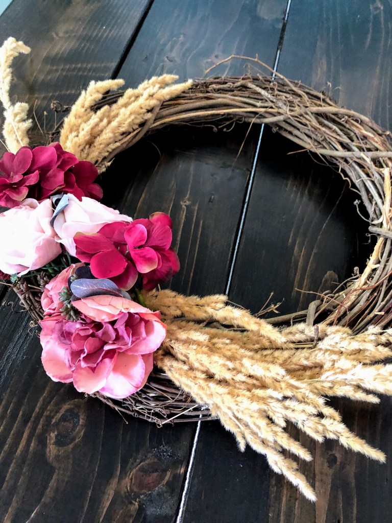 A fall cottage wreath on a wood dining table.