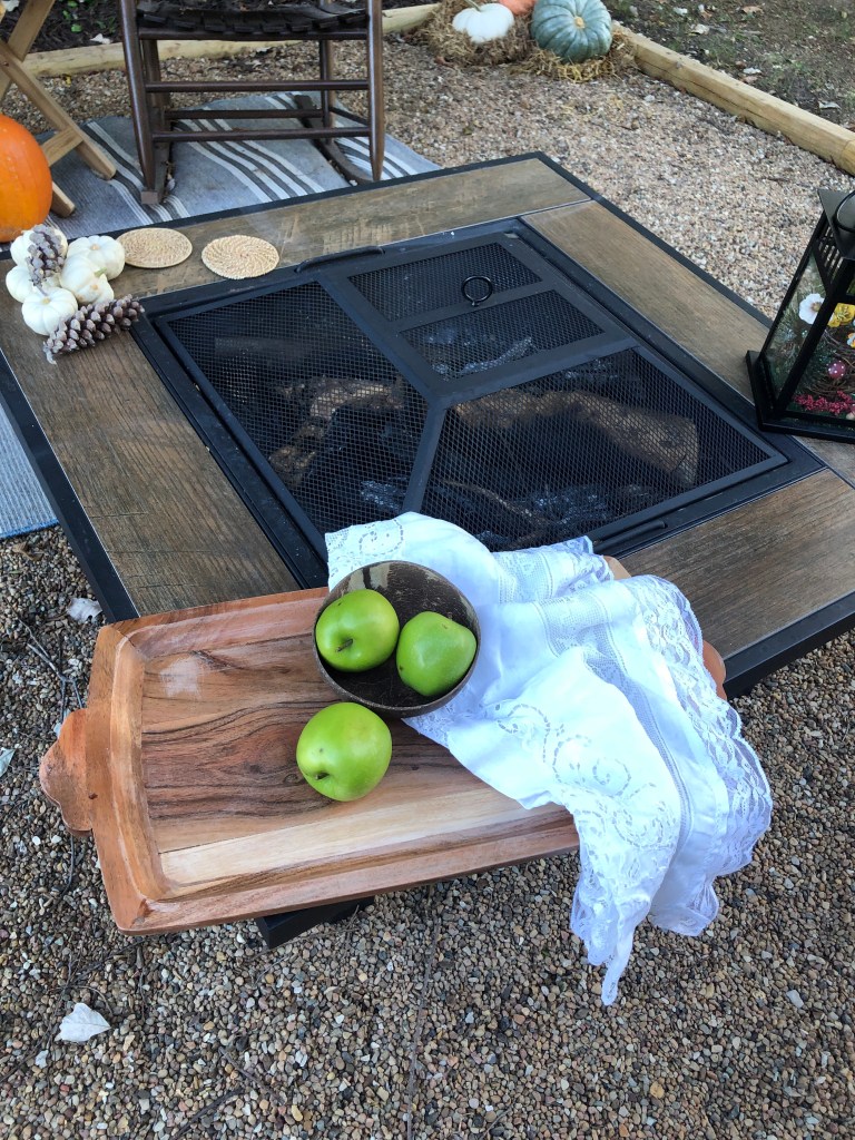 Green apples and a white linen sit on a wood tray.