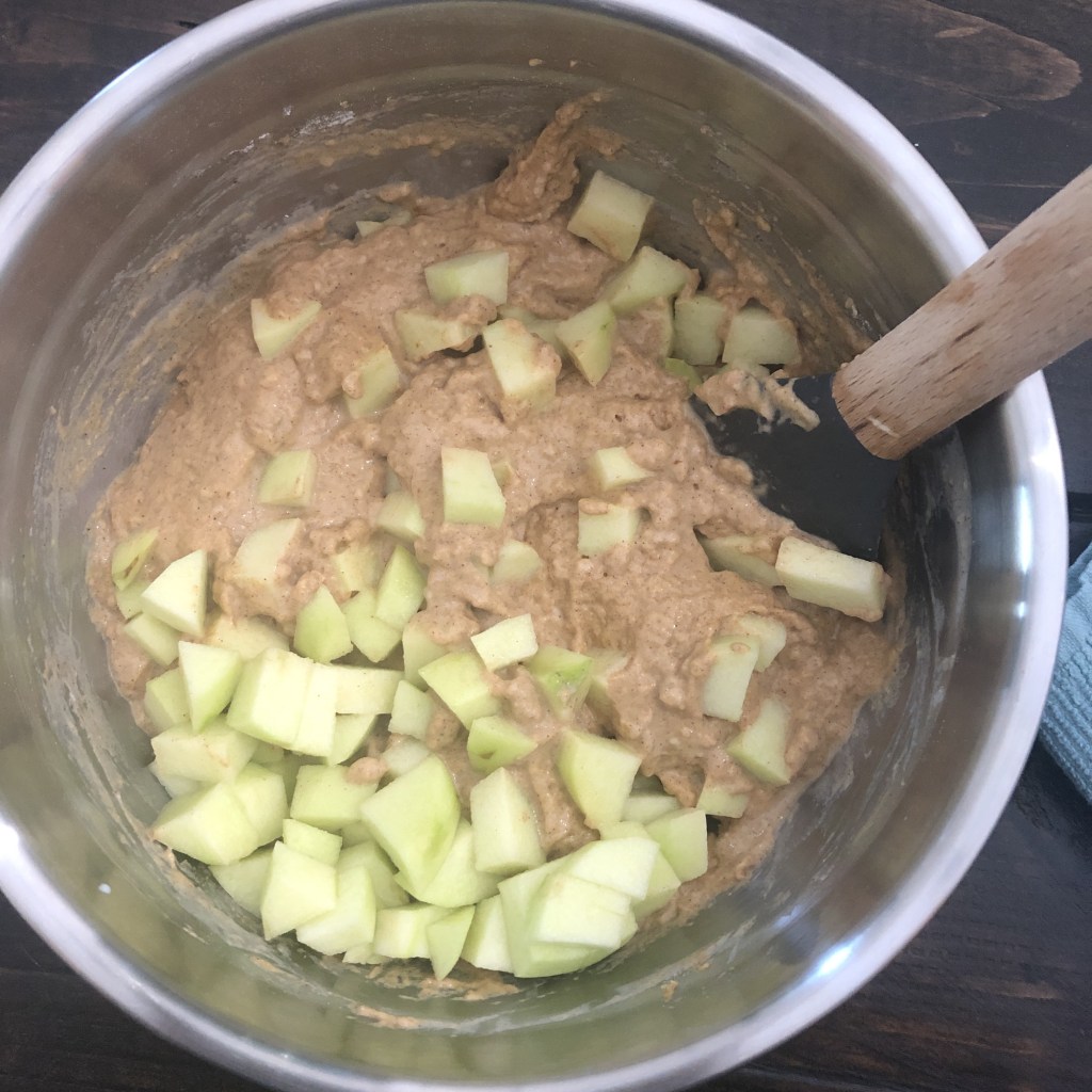 Diced apples have been added to a pumpkin apple fall muffin batter.