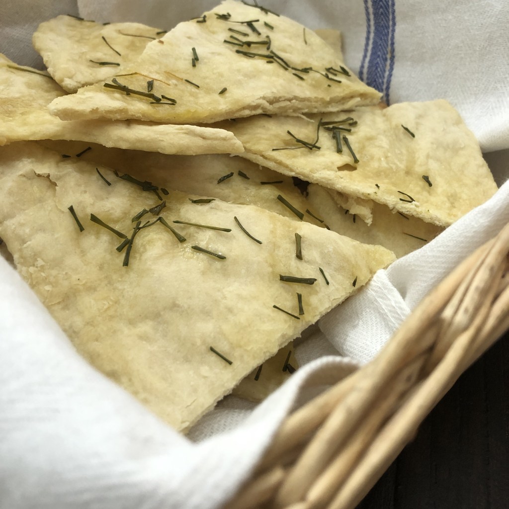 Flatbread lays in a bread basket on a table.