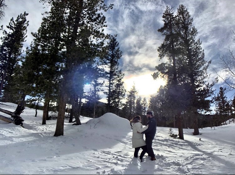 A couple embraces in the wintery area around Lily Lake in Estes Park.