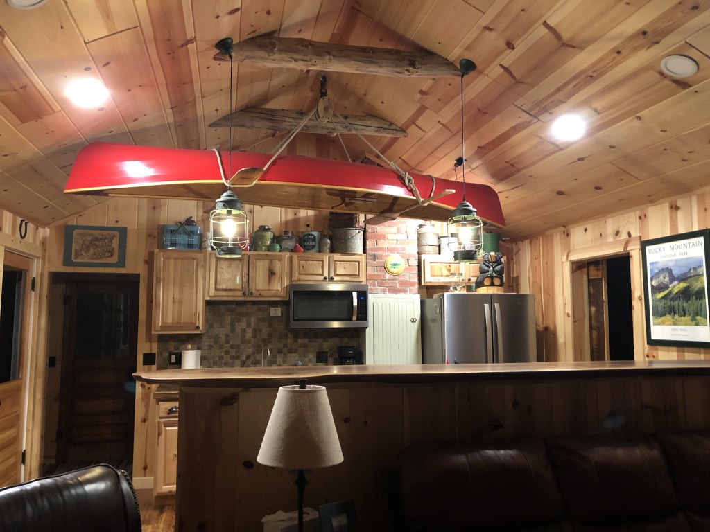 Honeymooning in Estes Park done right in a cabin packed full of rustic decor, including a canoe hanging from the kitchen ceiling.
