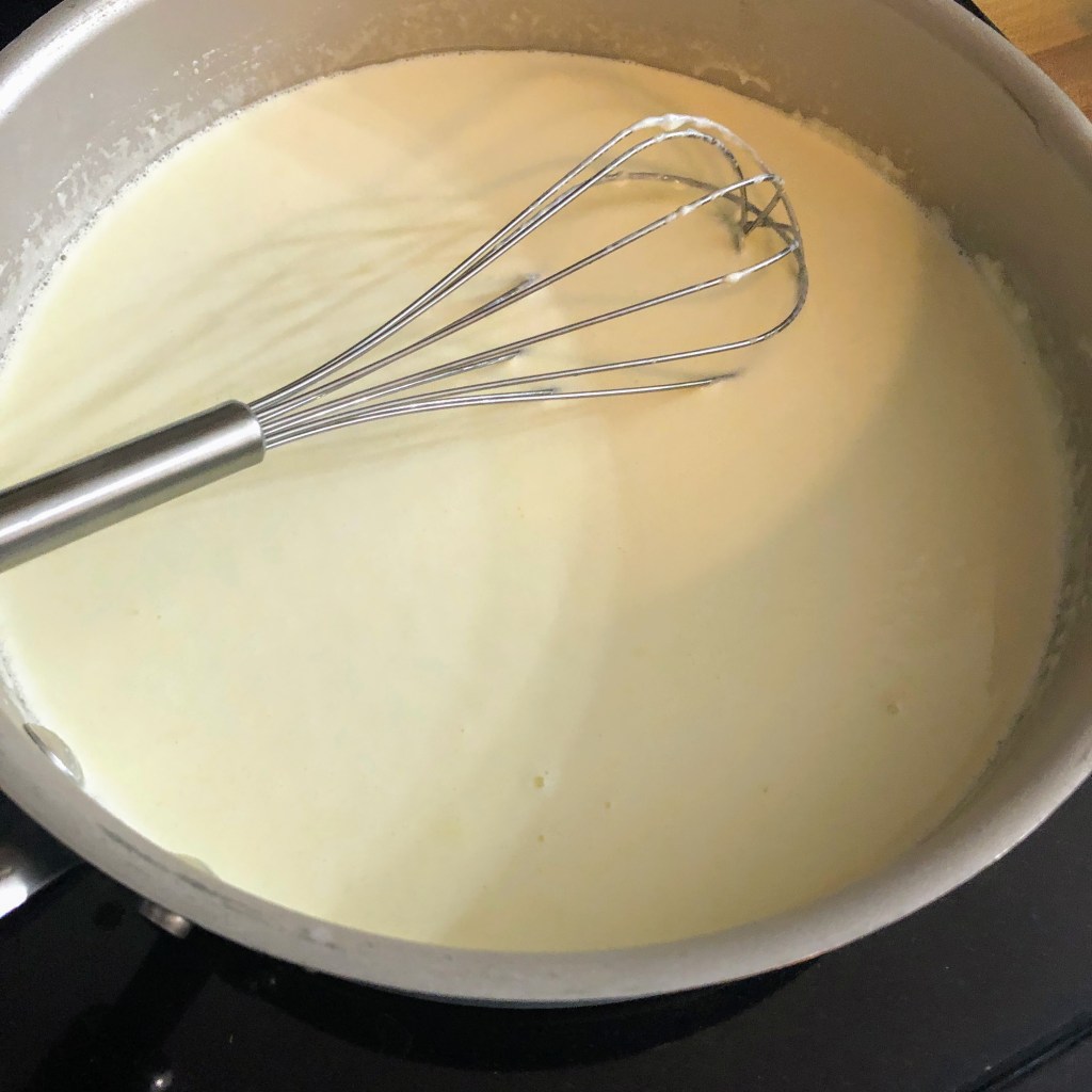 A milk and cream mixture simmers on a the stove.
