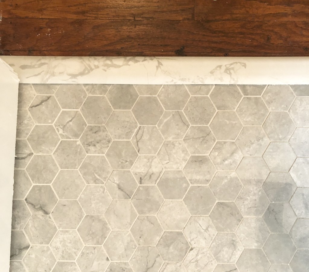 A marbled threshold has been added to marbled floor tiles. 