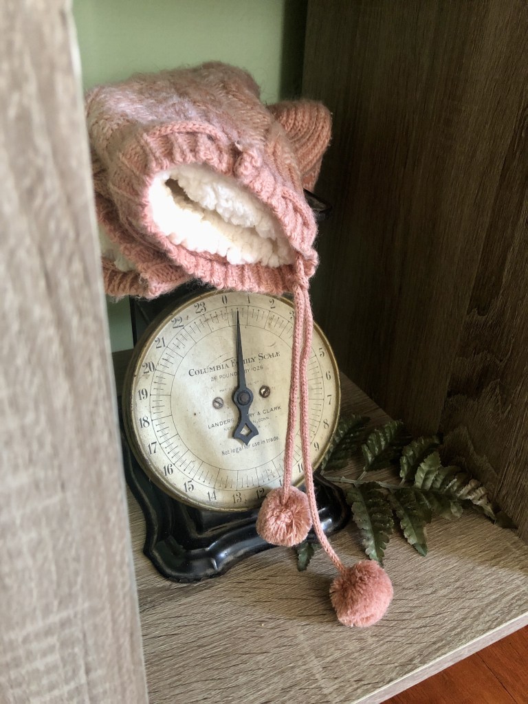 Cozy, comfy knitted stockings lay on a vintage antique scale.