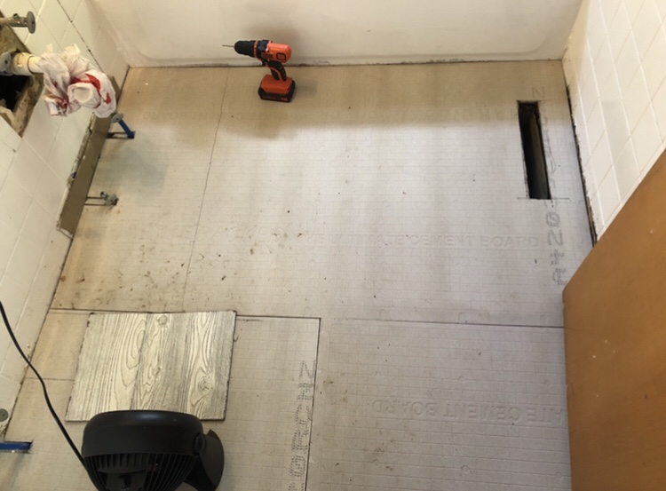 A bathroom floor is being worked on as part of home renovations in an old home.