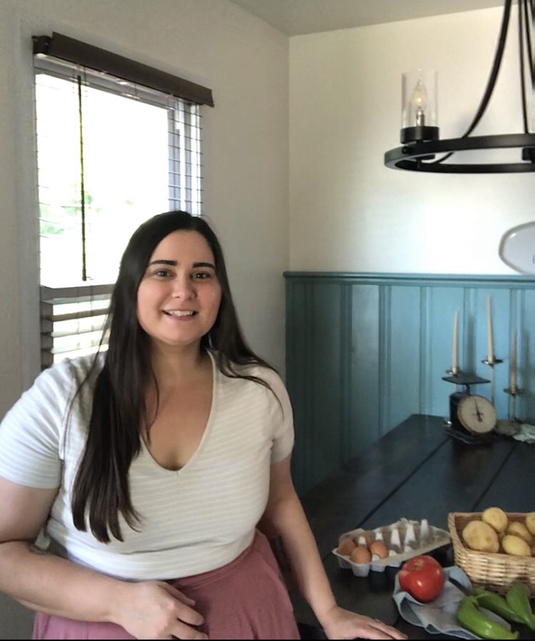 A woman stands in her dining room, surrounded by produce after spending so much time on one of her latest home renovations.