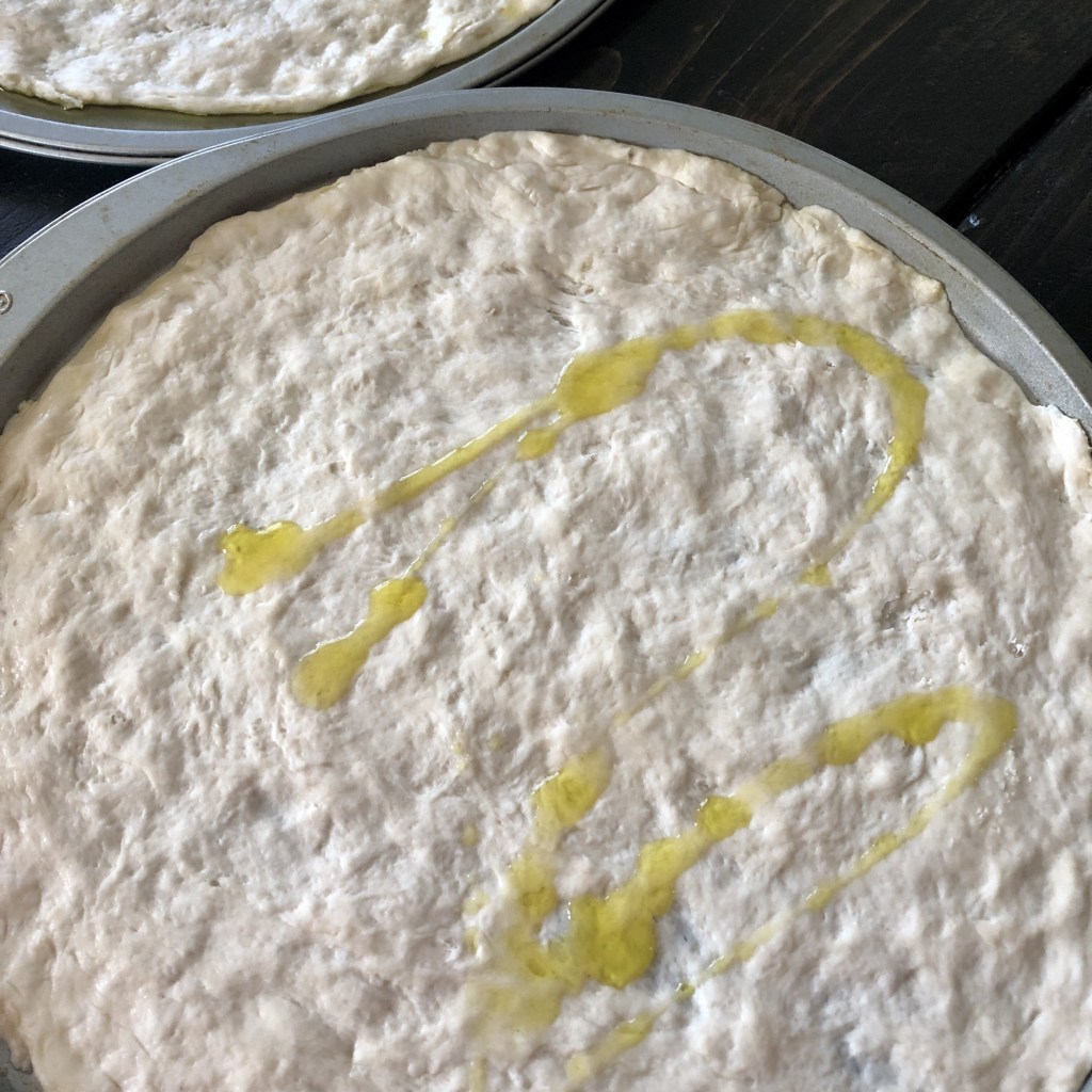 A pizza crust had been drizzled with olive oil just before baking.