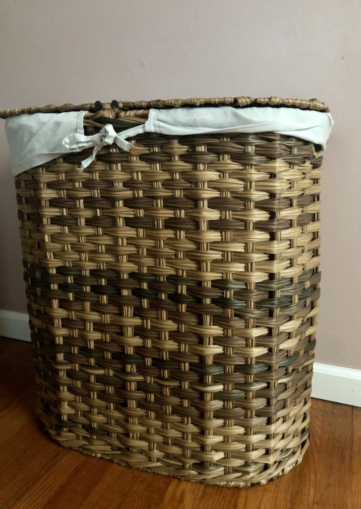 A laundry basket is an important component to keeping a tidy home. Here, a woven basket is lined with linens in a master bedroom.