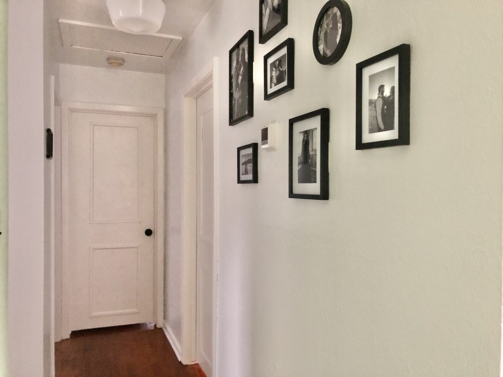 A hallway has been painted white from top to bottom to open up the space.