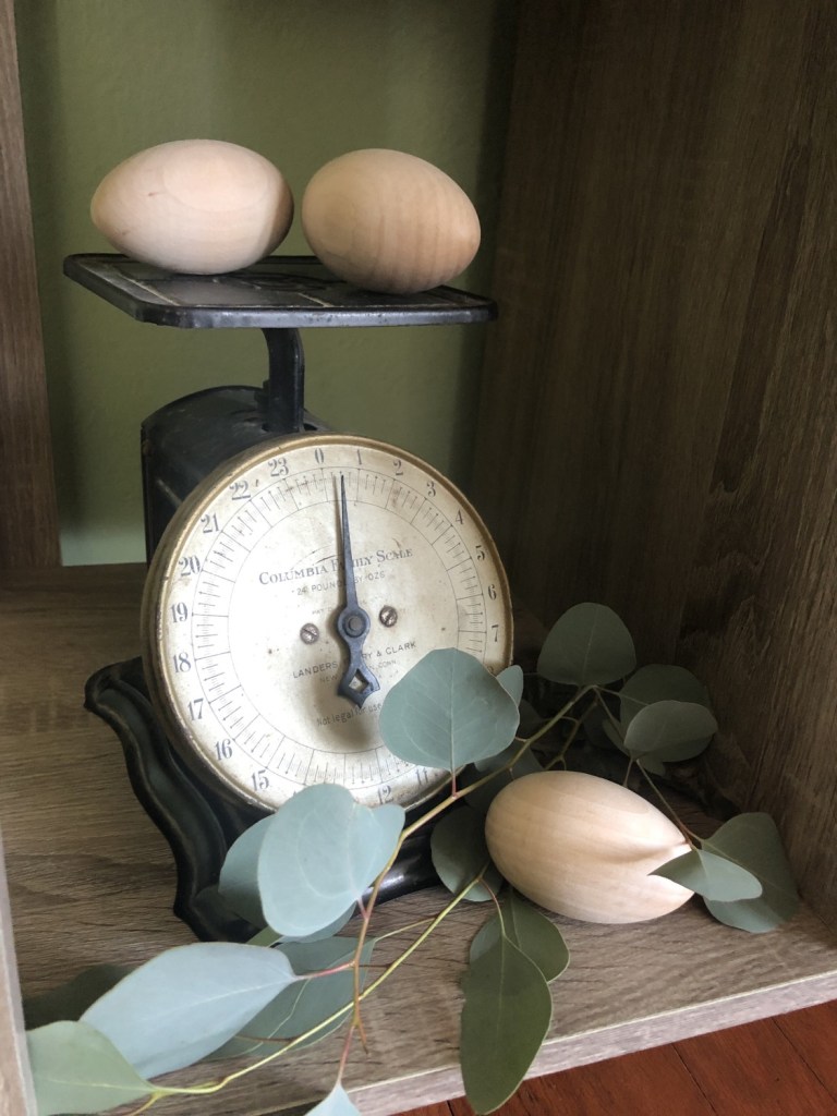 Wooden eggs sit on a vintage scale in a nook inside a cottage.