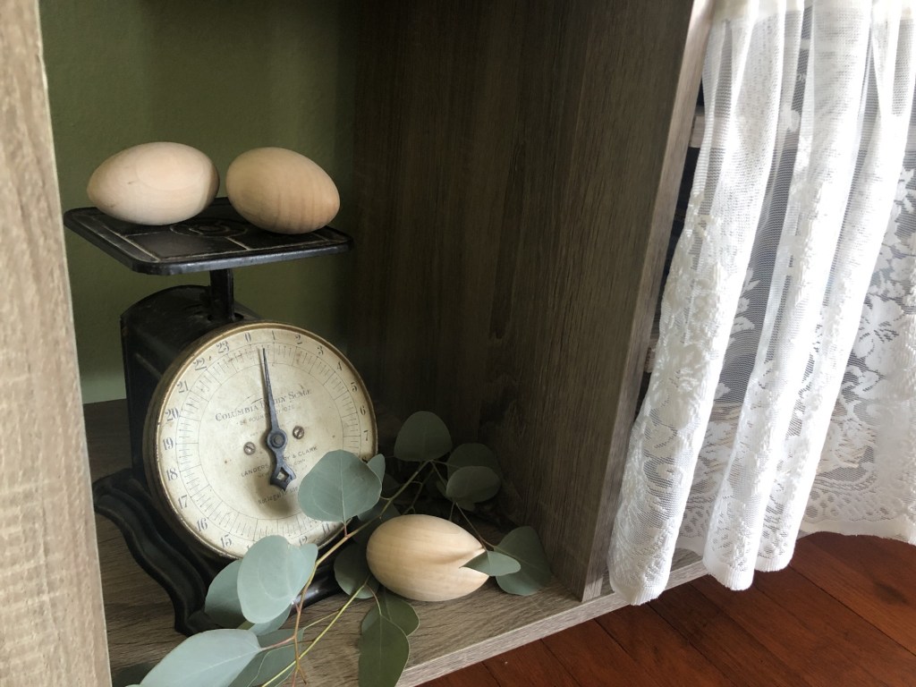 Spring cottage decorating ideas are complete with a vintage scale and wooden eggs.