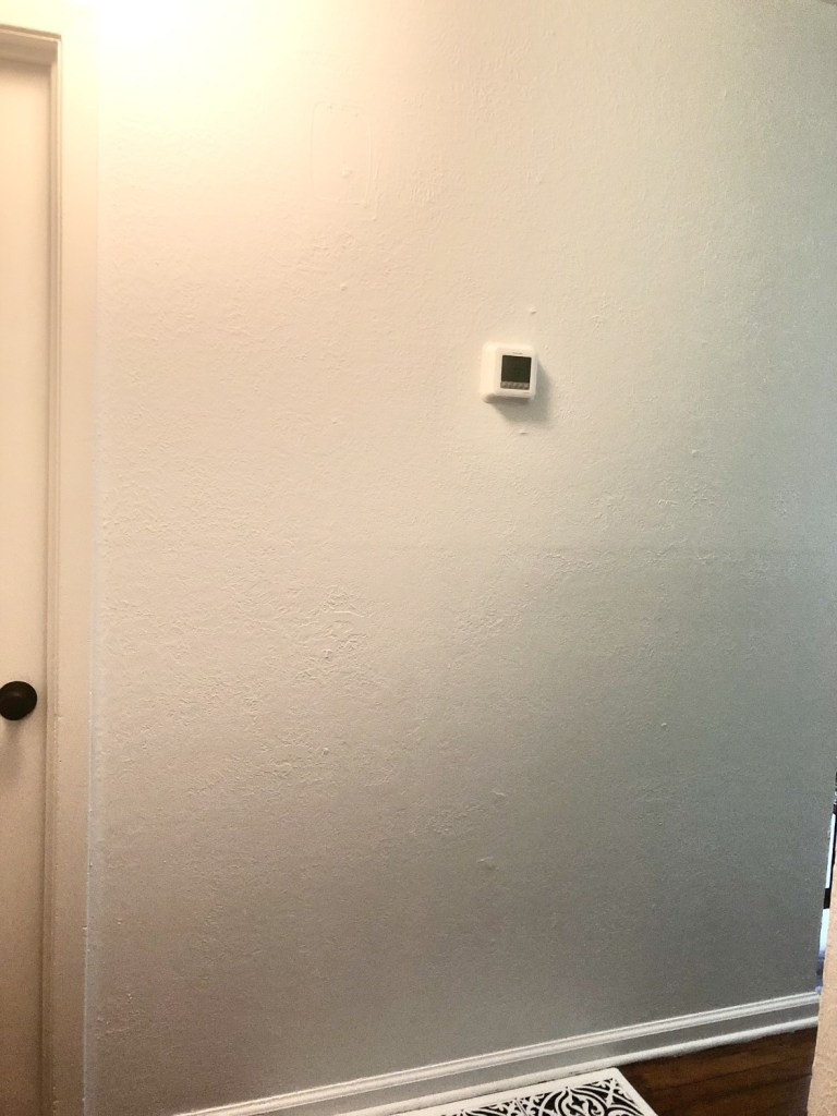 A white wall is completely bare for creating a black and white gallery wall.