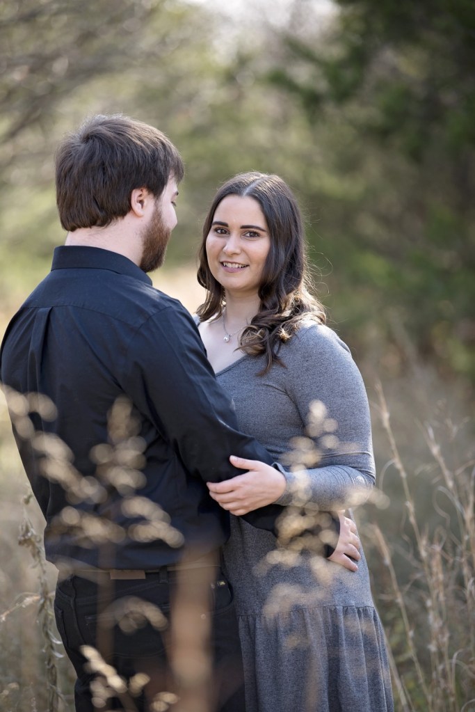 A man and woman embrace as they have their engagement photos taken.
