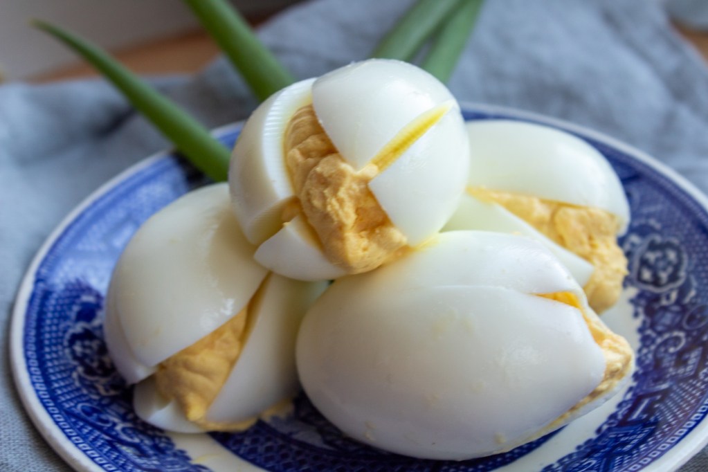 A deviled egg bouquet lays on blue china.