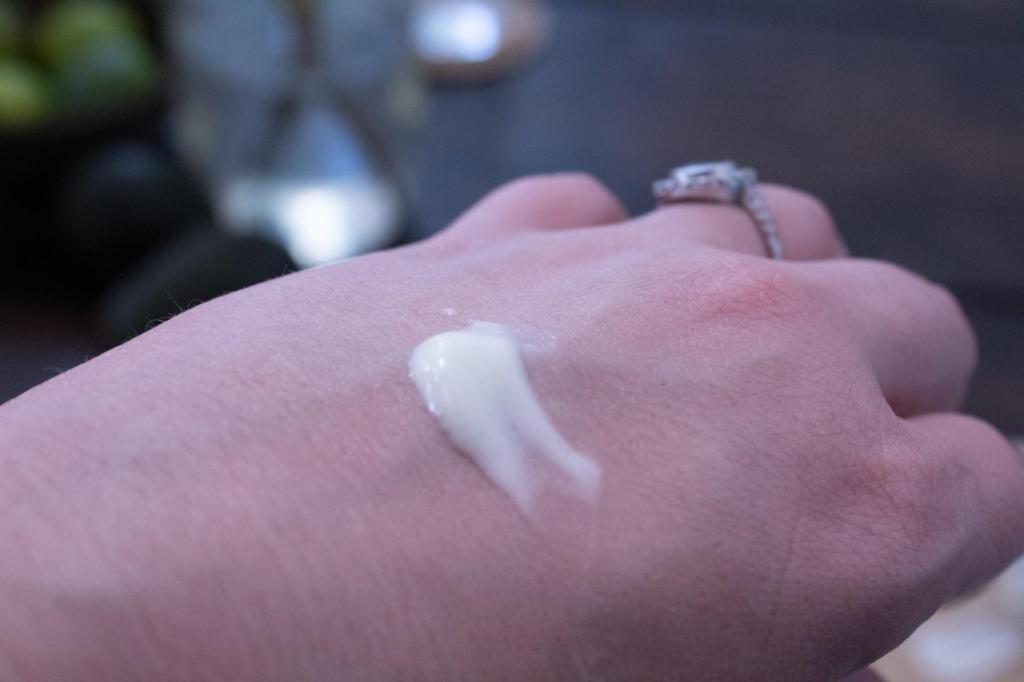 A woman adds a dollop of homemade body butter to her hand.