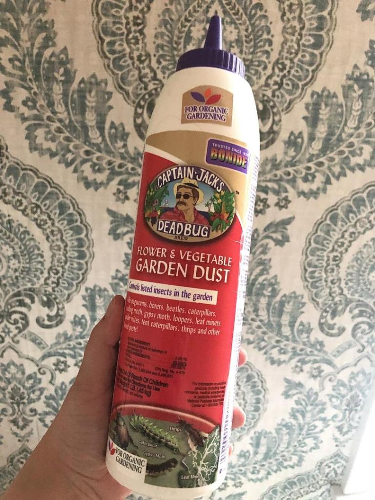 Organic pesticide is being held up by a woman's hand.