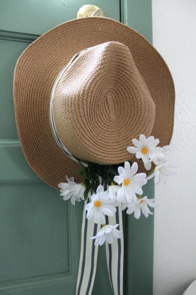 A summer wreath is hanging on a doorknob in a kitchen.
