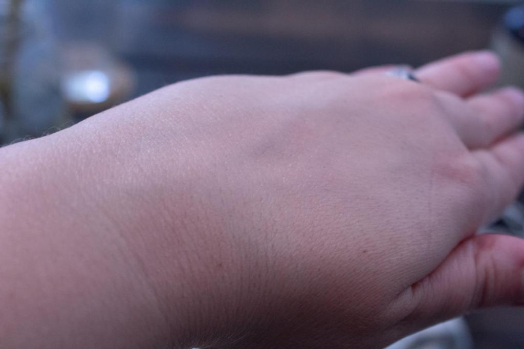 A woman shows her hand and how easily her body butter absorbed into her skin instantly.