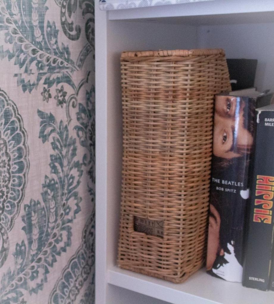 Bookcase styling stores many pieces inside attractive wicker folders.