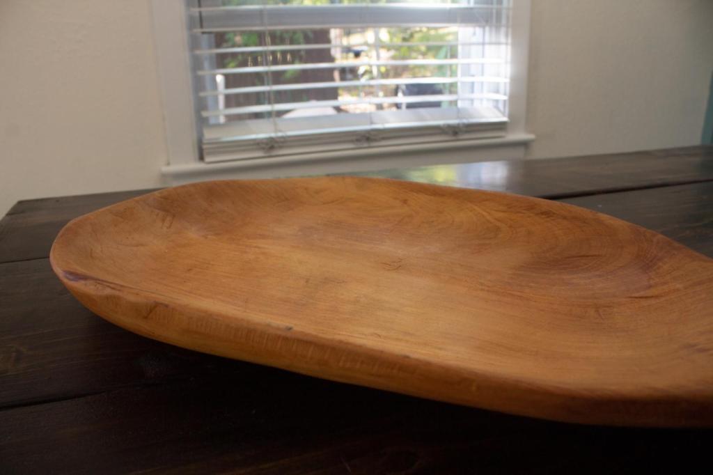 An old wooden platter is laying on a table.