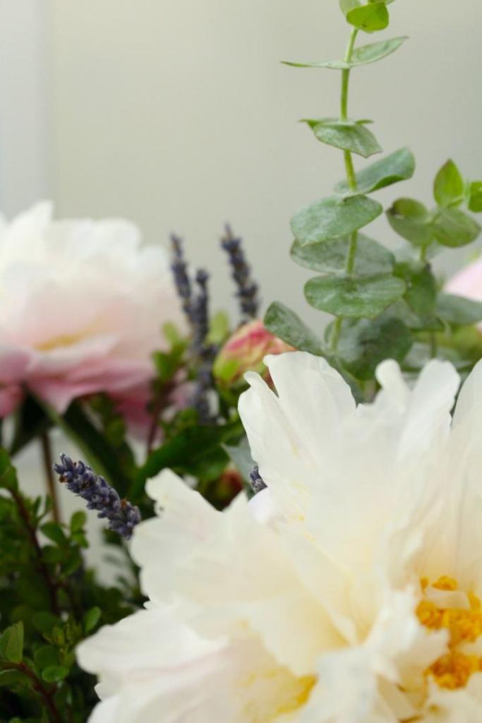 DIY flower arrangements are in a pitcher on a table.