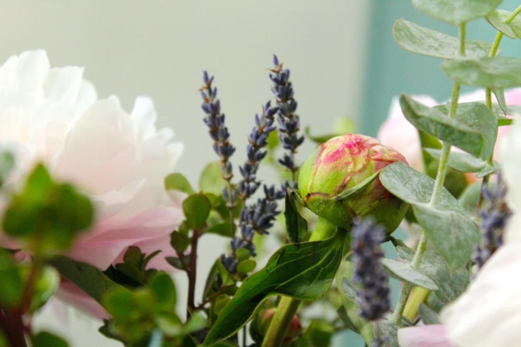 Flowers dance together in a white vase.