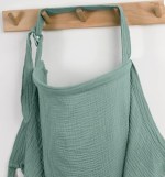 A green nursing cover hangs on a hook.