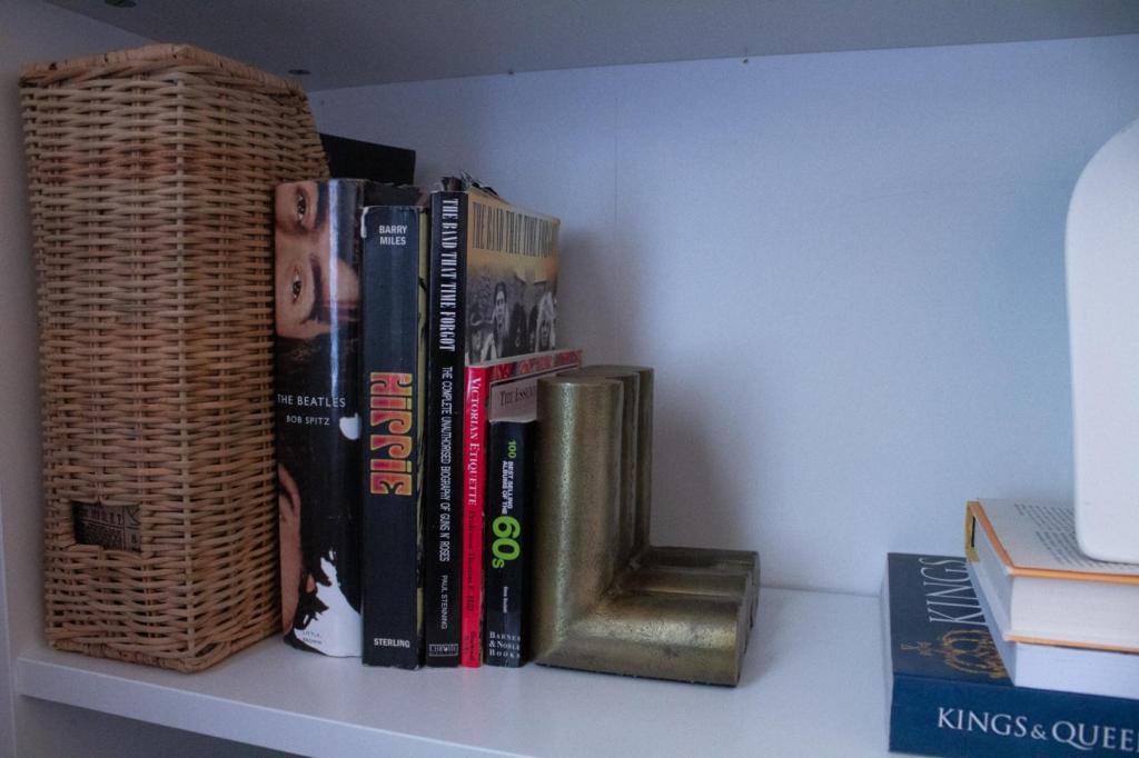 A bookend holds up a few pop culture books on a shelf.