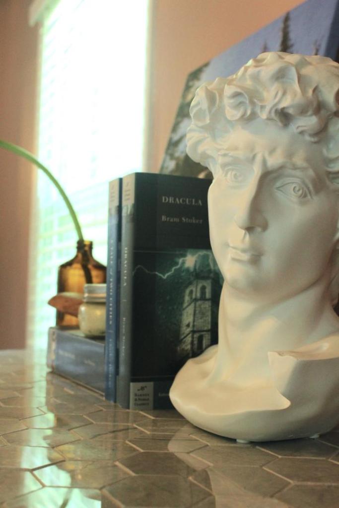 A dresser is shown with its marble tiles and a head bust on top.