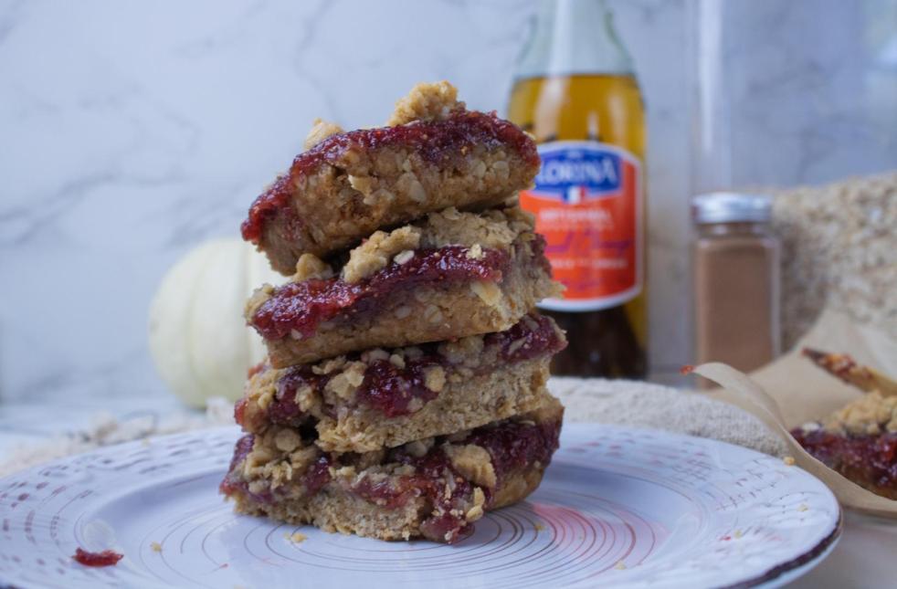 Breakfast Jam-Filled Bars Recipe is ready to eat with bars stacked on one another in front of white mini pumpkins.