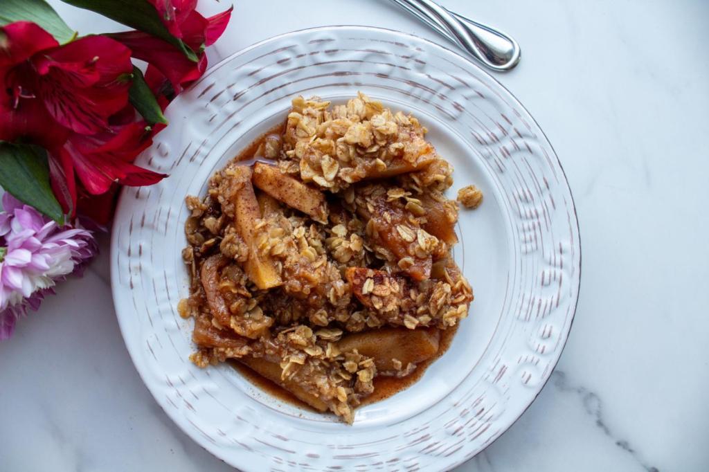 Flowers and apple crisp are placed on a white marble countertop.