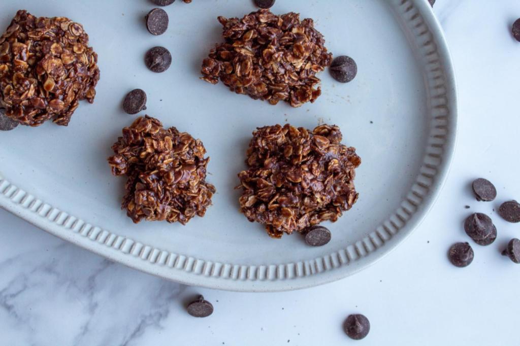 Chocolate Oatmeal No-Bake Cookies without peanut butter are plated on an oval platter and scattered with chocolate chips.