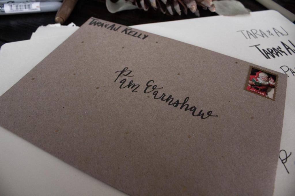 A woman's name is hand lettered onto the front of an envelope.