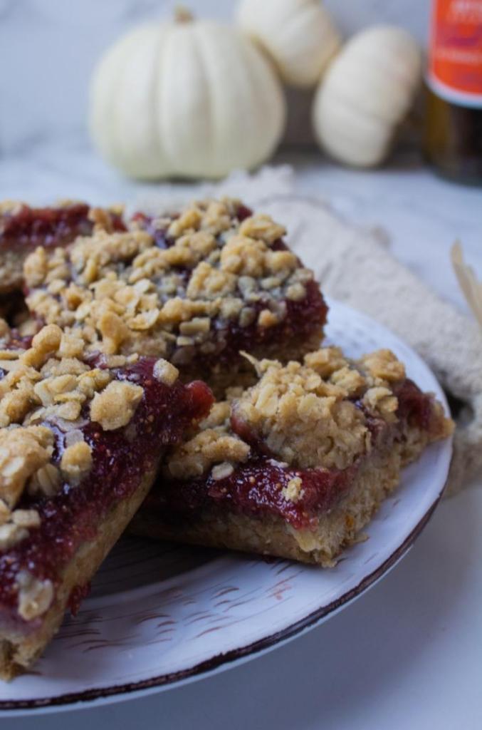 A breakfast bars recipe has been arranged on a plate in front of small white pumpkins.