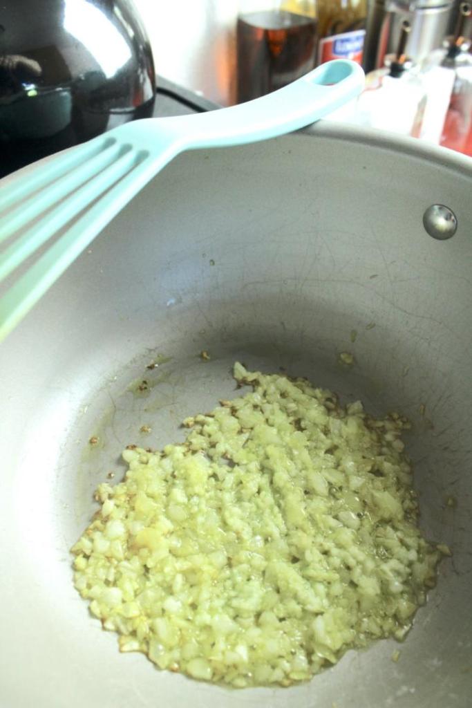 Diced onions are sautéed in a saucepan.