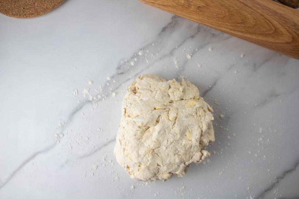 Dough is plopped onto a lightly floured countertop for making easy, fluffy biscuits.