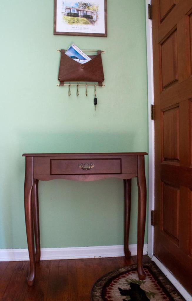 A table sits near a doorway and is ready to be refinished.