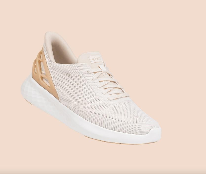 Kizik shoes are athletic and stylish and pictured in a cream and light pink color.