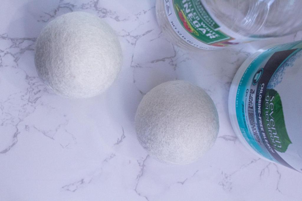 Wool dryer balls sit on a marble countertop.