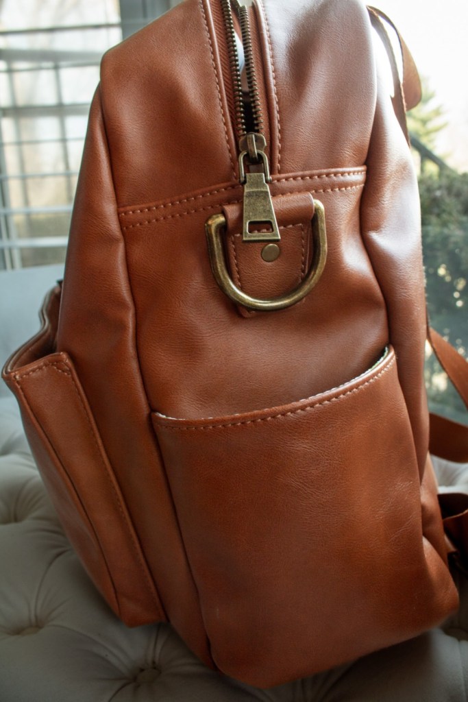 A diaper bag in vegan leather is shown from the side.