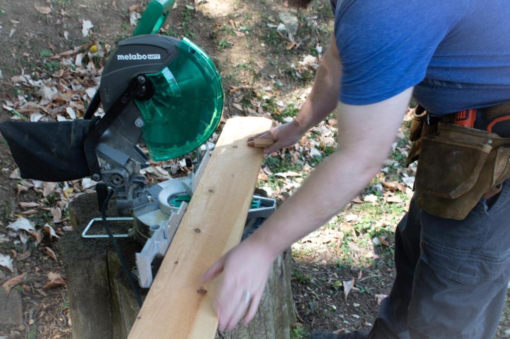 A man lines up wood with a circular saw to trim the edges off.