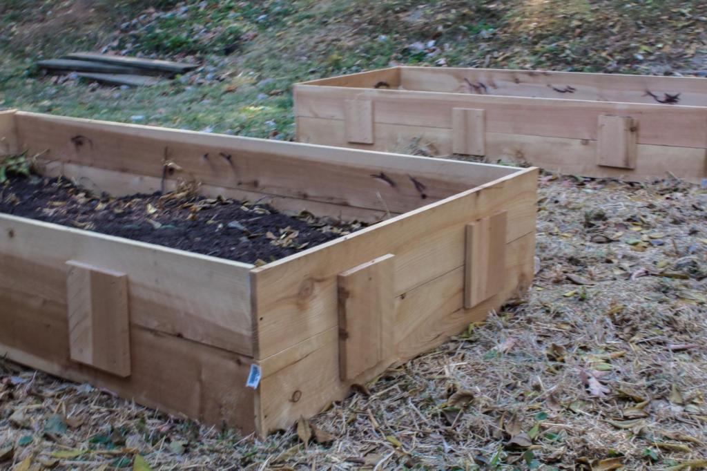 Inexpensive raised garden beds are filled with dirt.