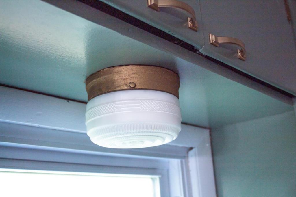 How to use rub n buff on metal is shown by a vintage light fixture after being madeover.