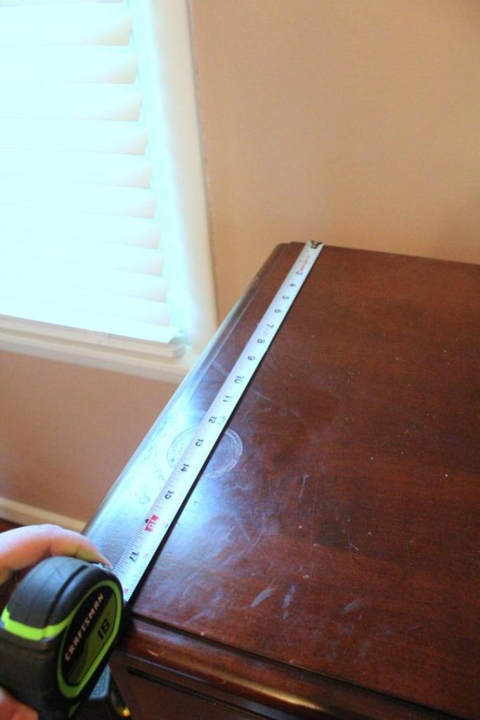A dresser is measured.