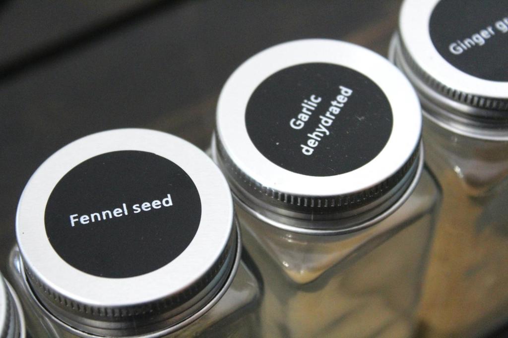Spice jar lids are in view after being labeled.