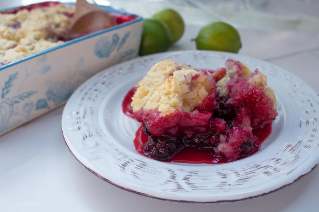 Blackberry cobbler is served on a small plate on a marble countertop.