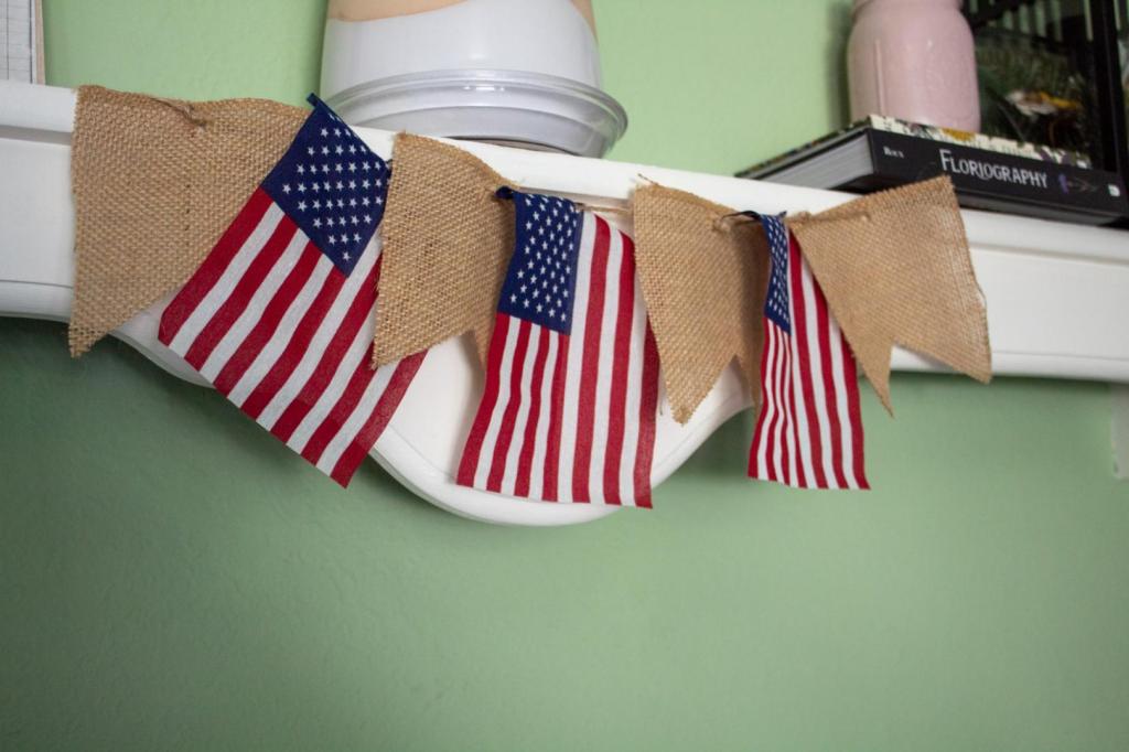A mini DIY Fourth of July banner is laid across a mantle.